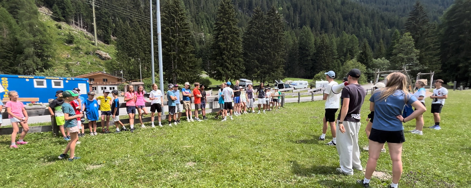 Die JuBla-Schar spielt gemeinsam auf einer Wiese in den Bergen